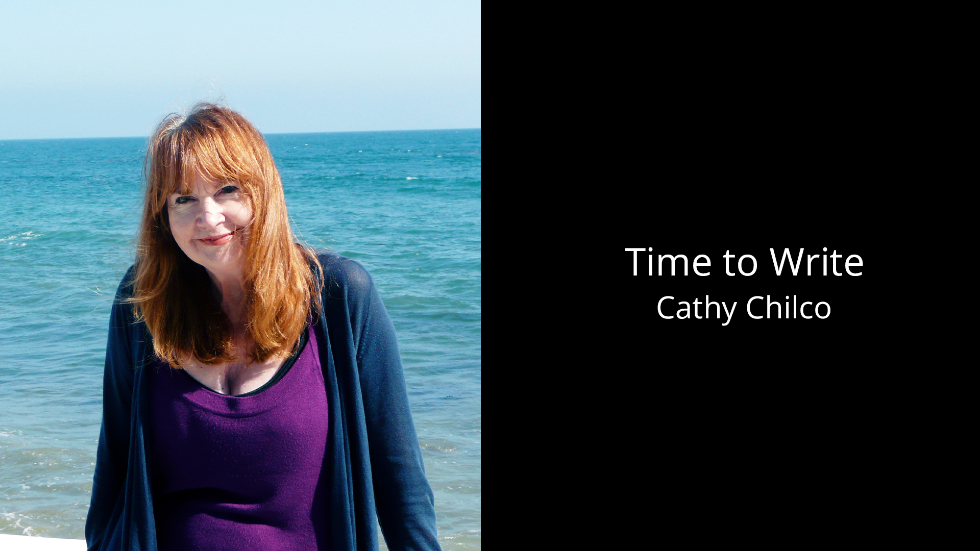 Cathy Chilco stands in front of the blue glimmering ocean on a sunny day.